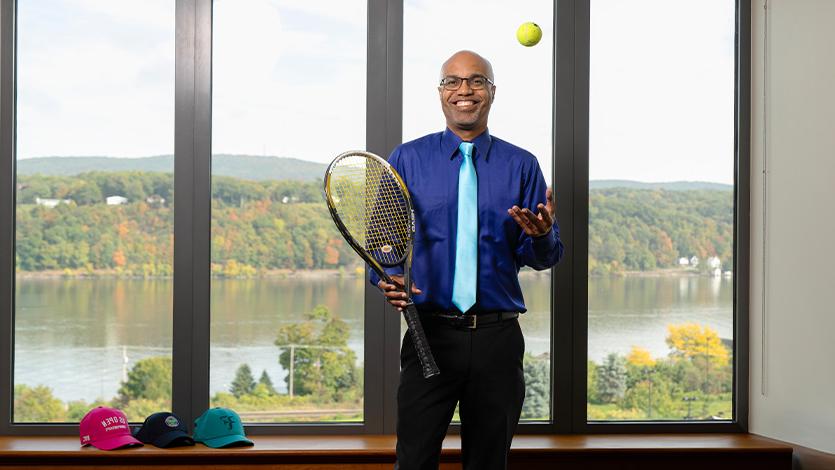 Image of Dr. Buckmire with tennis equipment. 